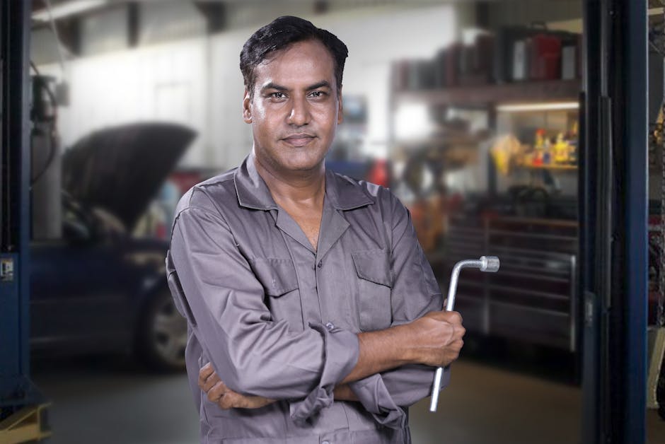 Smiling auto mechanic standing in a modern repair facility